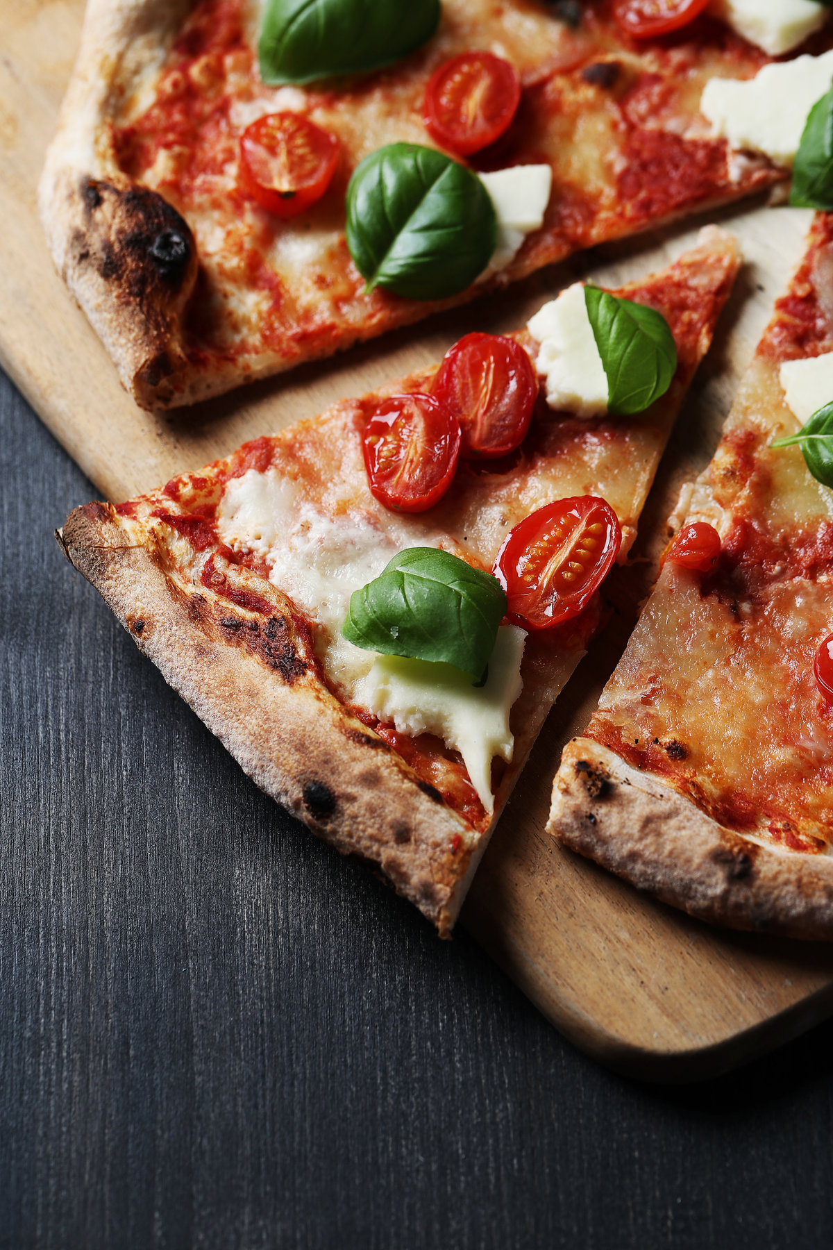 Pizza garnie de tomates, mozzarella et basilic